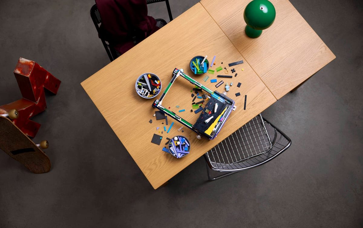 Le Flipper d'arcade LEGO Icons vu de dessus, posé sur un bureau en bois