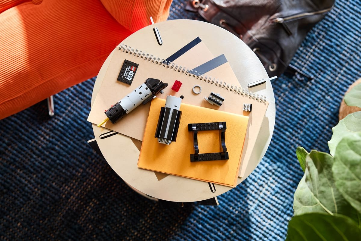 Les éléments du sabre laser LEGO disposés sur une table basse avant assemblage