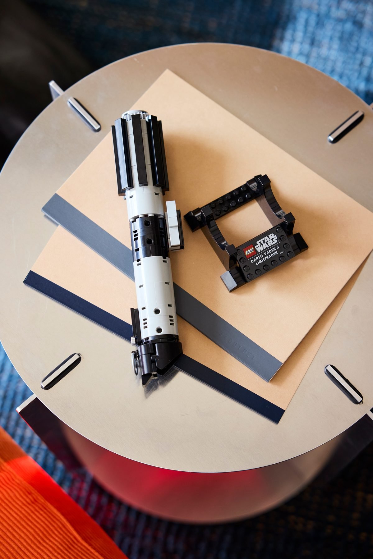 Le sabre laser LEGO et son présentoir séparés, posés sur une table basse