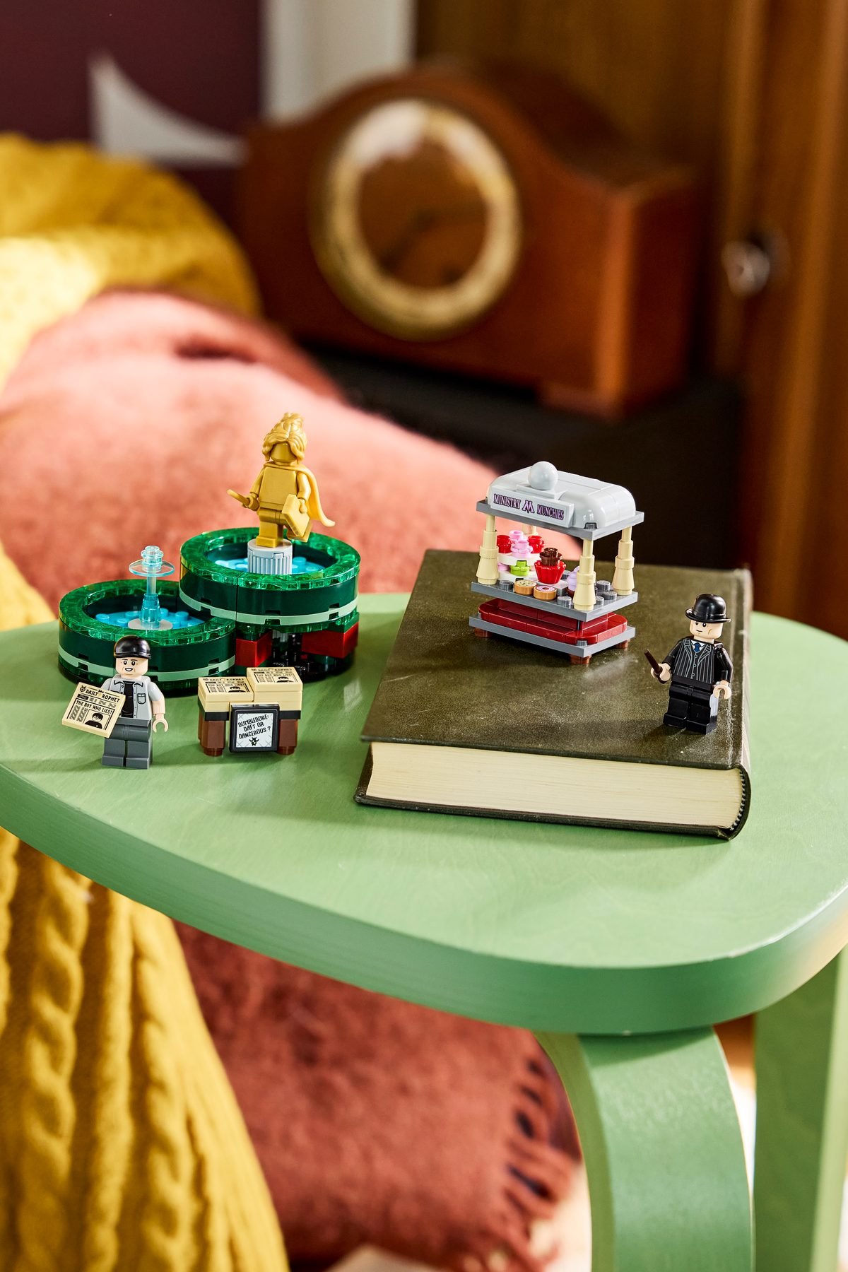 Le LEGO Harry Potter 40901 assemblé sur une table de chevet, kiosque à café posé sur un livre