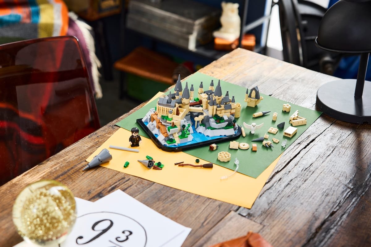 Le château de Poudlard miniature LEGO en cours de construction, pièces détachées étalées autour du socle