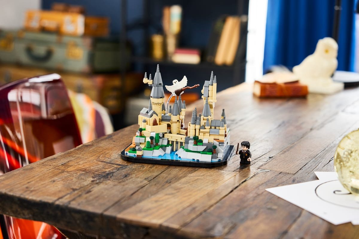 Le set LEGO 40975 exposé sur une table en bois, la minifigurine de Harry Potter posée à côté du socle
