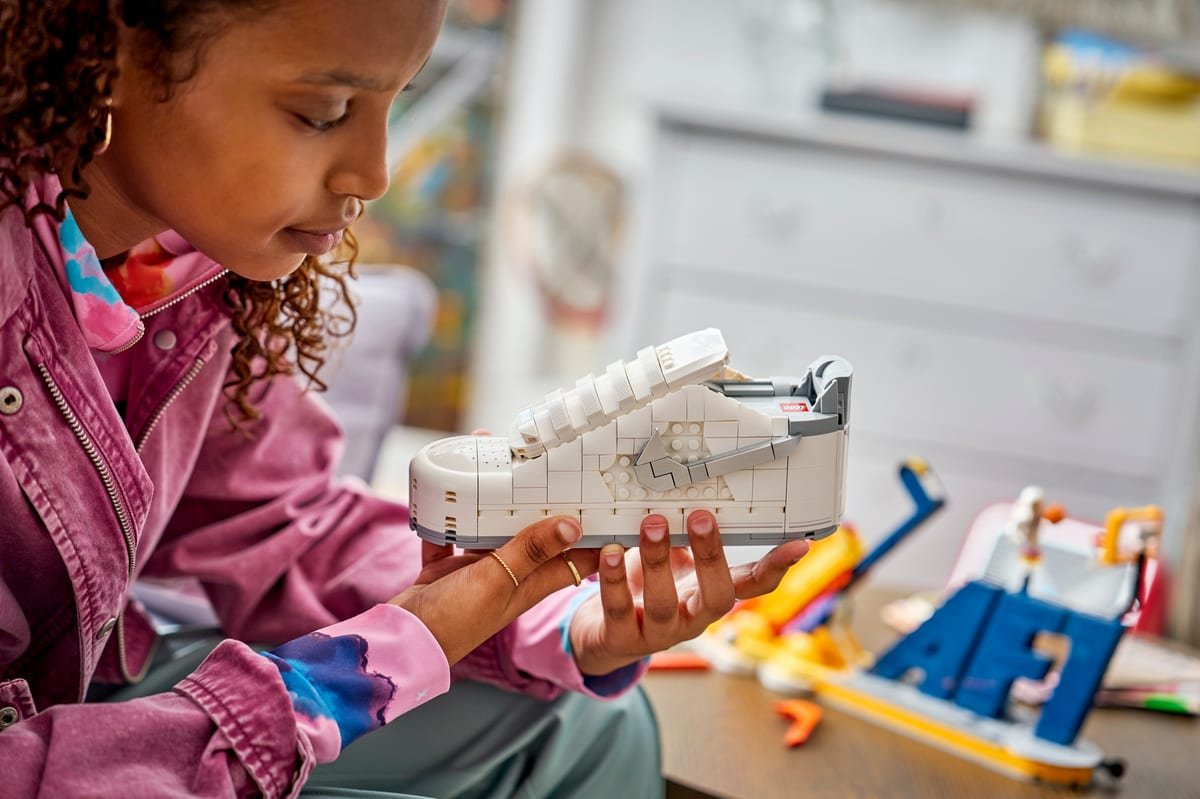 La chaussure LEGO Nike Air Force 1 tenue à deux mains, semelle et tige en briques blanches visibles