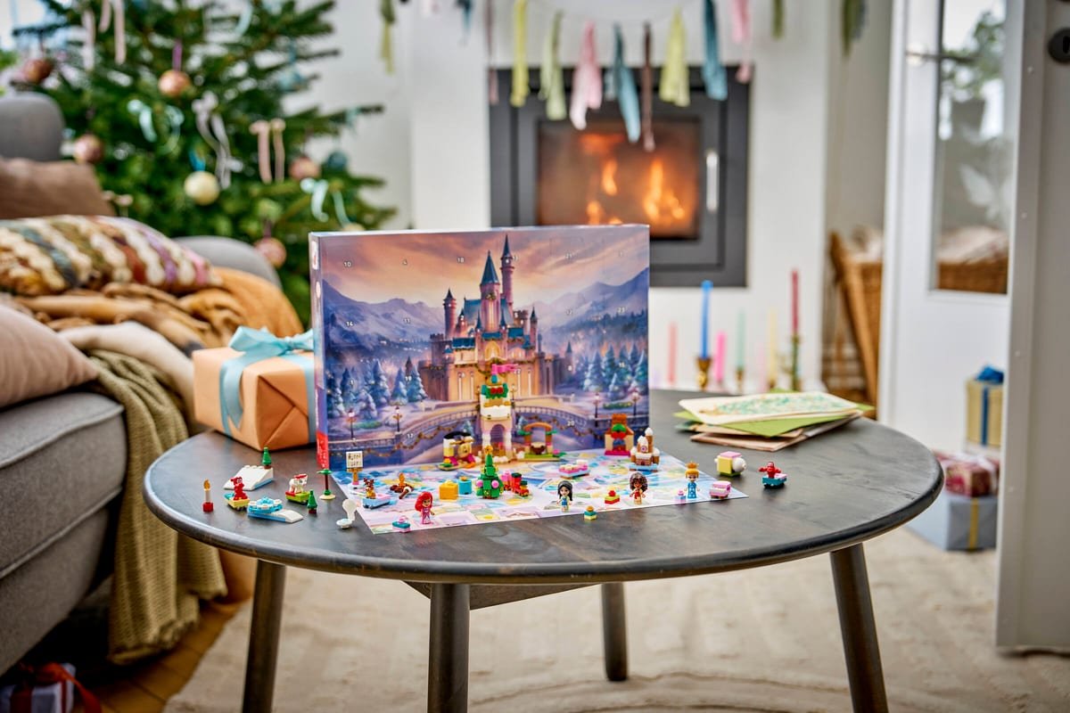 Le calendrier de l'Avent LEGO Disney déplié sur une table, devant une cheminée