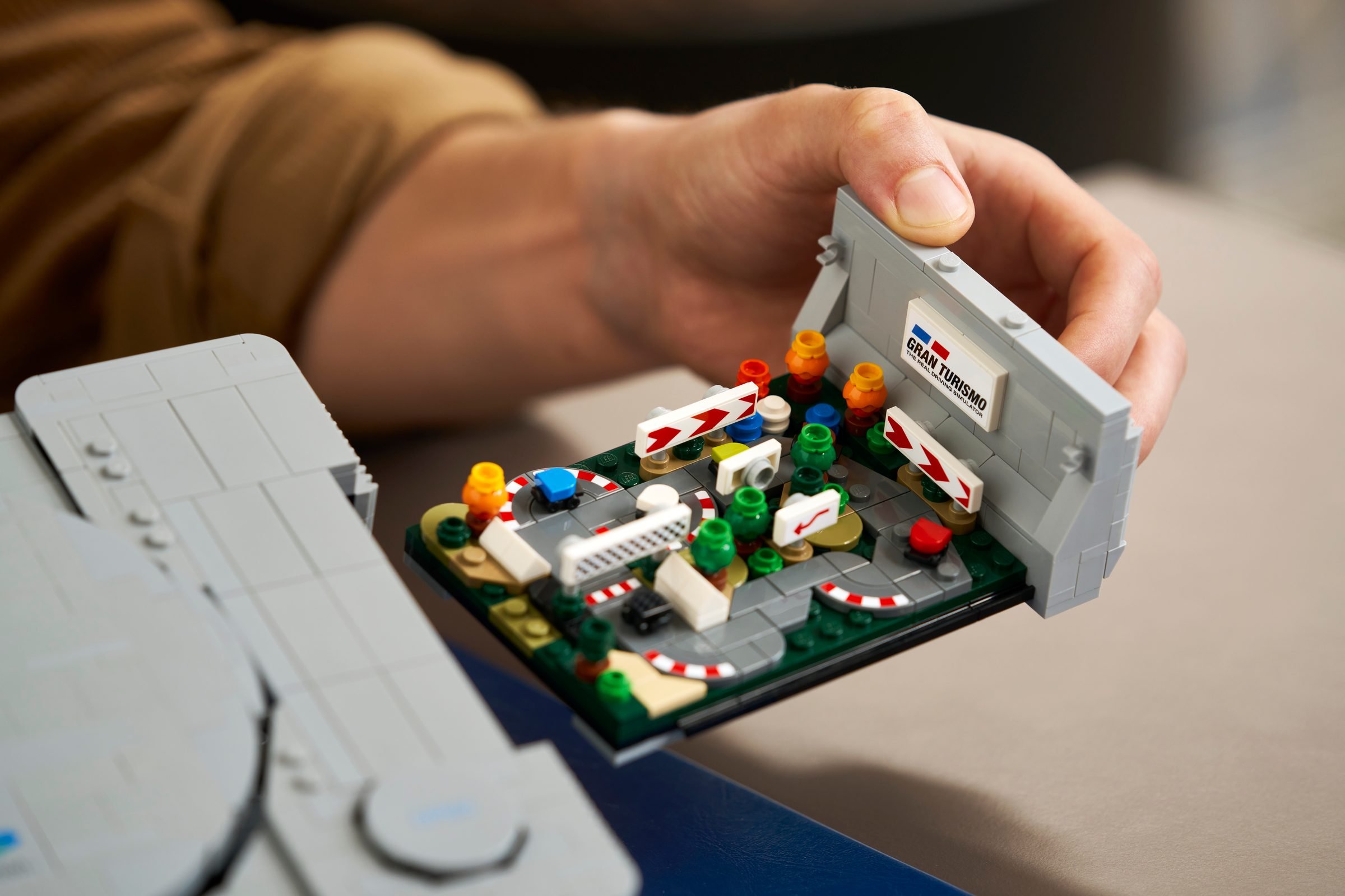 Une main sort le diorama Gran Turismo du flanc du LEGO PlayStation 72306