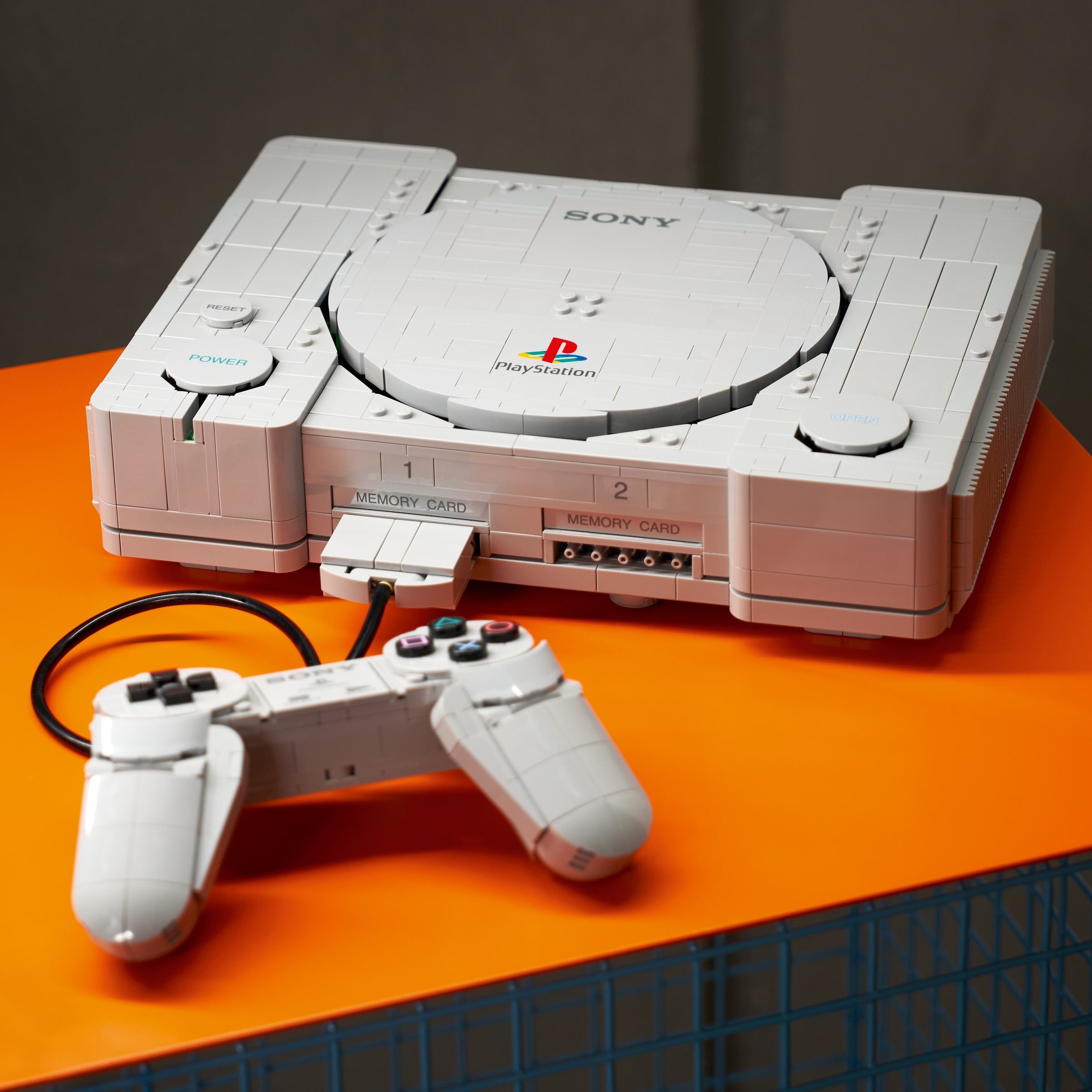 La console et sa manette assemblées, posées sur un plateau orange