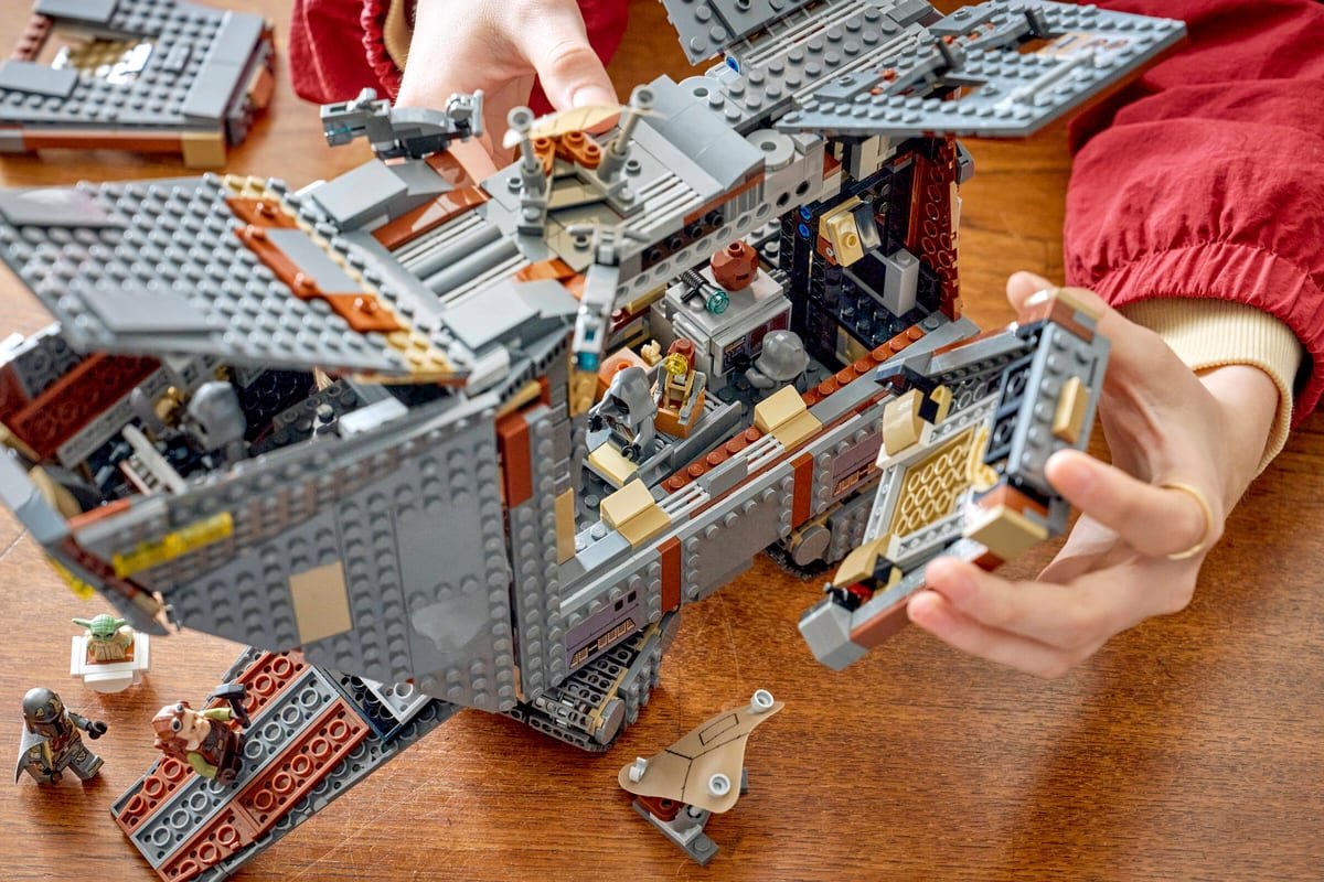 Scène de jeu autour du Sandcrawler : le Mandalorien, Grogu et Kuiil face aux Jawas sur le sable