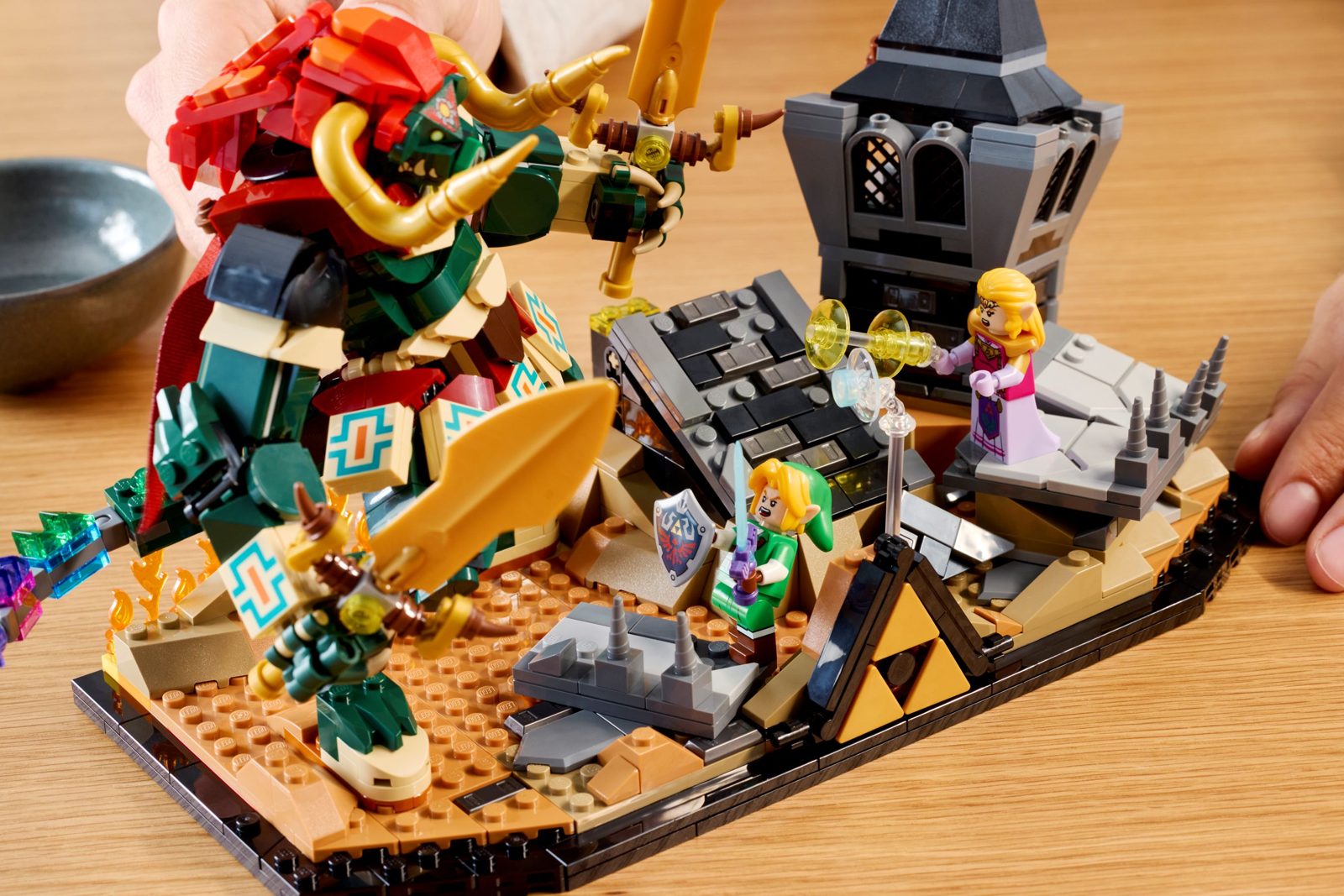 Le diorama LEGO 77093 vu de trois quarts : Ganon en briques, la Triforce au sol, la tour en ruine et les flammes